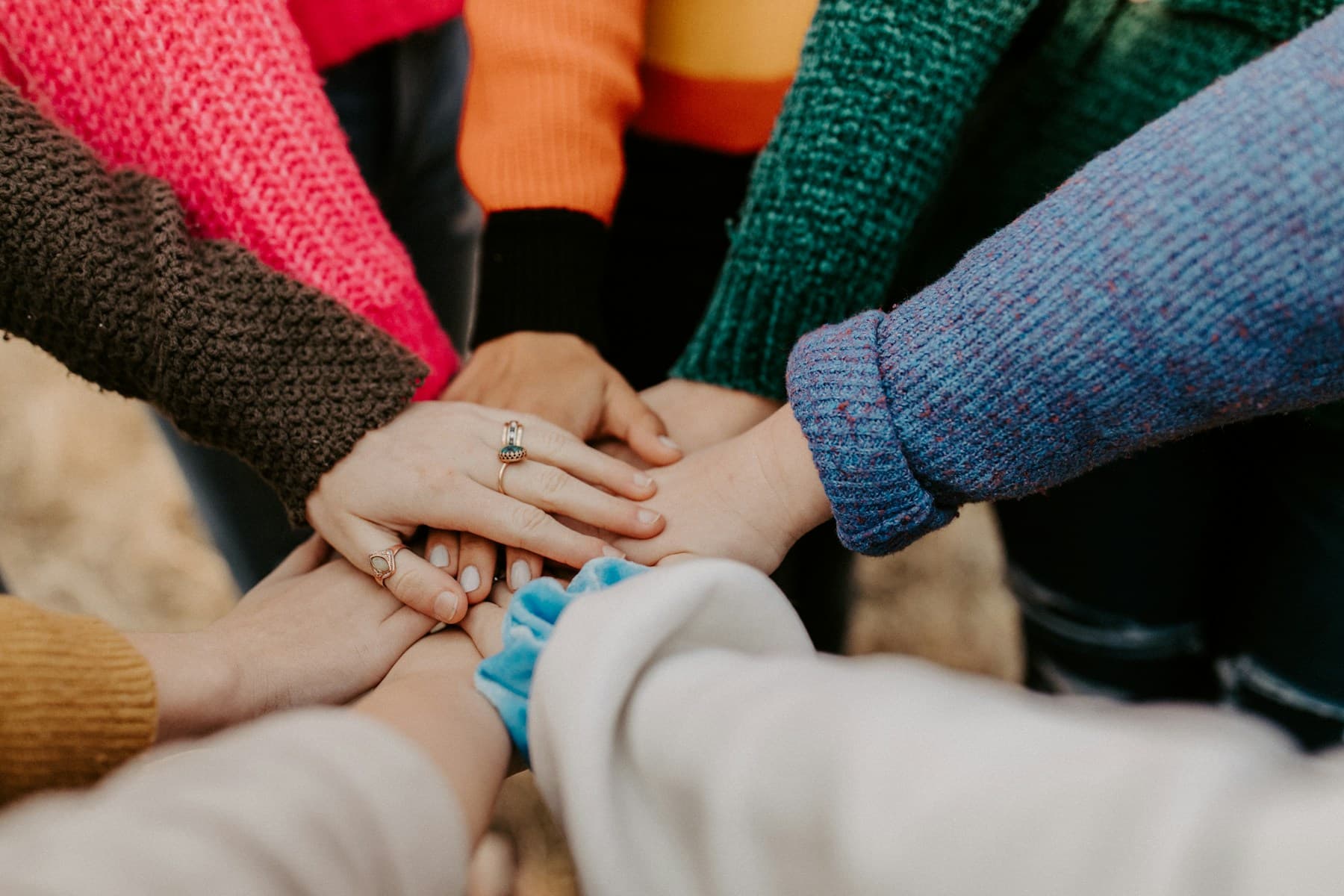Adults placing their hands together in a circle